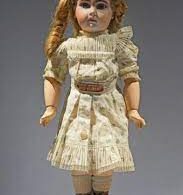 An assortment of antique dolls, showcasing a variety of styles and materials that reflect different historical periods and craftsmanship